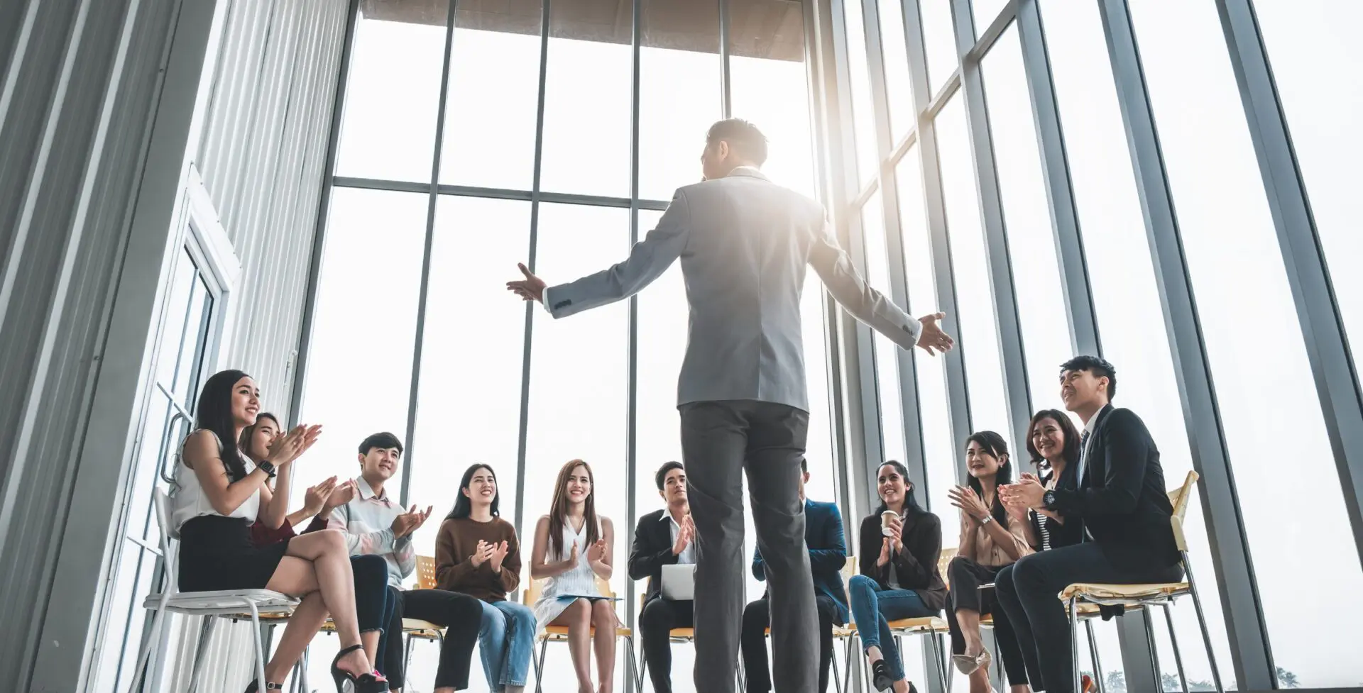 Business speaker engaging an audience in a modern meeting room.
