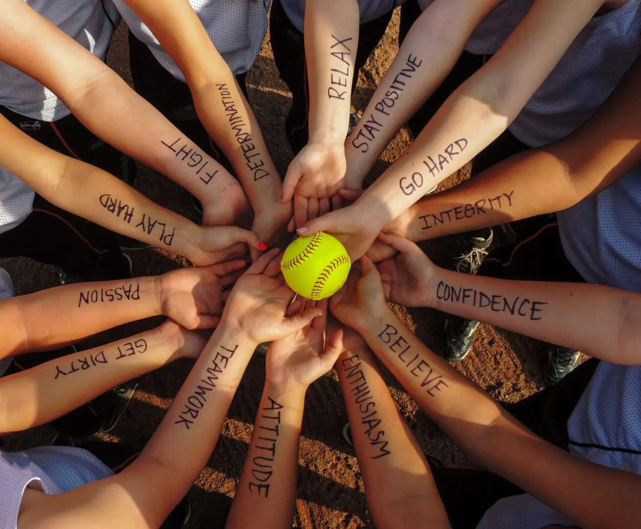 Hands form a circle, each with a positive word, holding a tennis ball in the center.